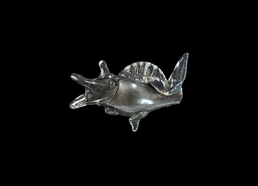 Post Medieval Venetian Glass Fish Bead: 18th century AD. A lampwork bead formed as a fish with gaping mouth, applied ribbed fin and tail. 2.94 grams, 35 mm (1 1/4"). Property of a London gentleman; acquired before 1980.