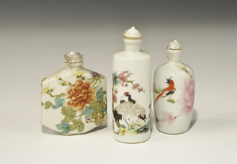 Chinese Ceramic Enamelled Snuff Bottle Group: 20th century AD. A mixed group of polychrome ceramic snuff bottles comprising: one cylindrical with birds and flowers; one cylindrical with two birds in a landscape; one rectangular with chrysanthemum