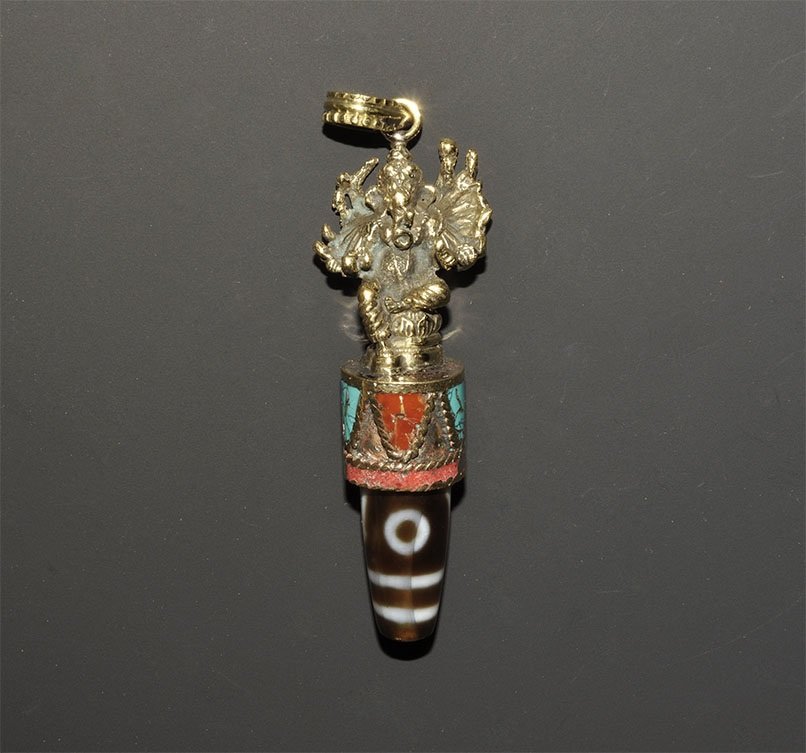 Nepalese Style Gilt-Bronze Ganesh and Eye Bead Amuletic: An undated archaistic composition tzi bead with three eyes mounted in a gilt-metal sleeve with figure of Ganesh above. 33 grams, 86mm (3 1/2"). From a central London collection formed between 1990-200