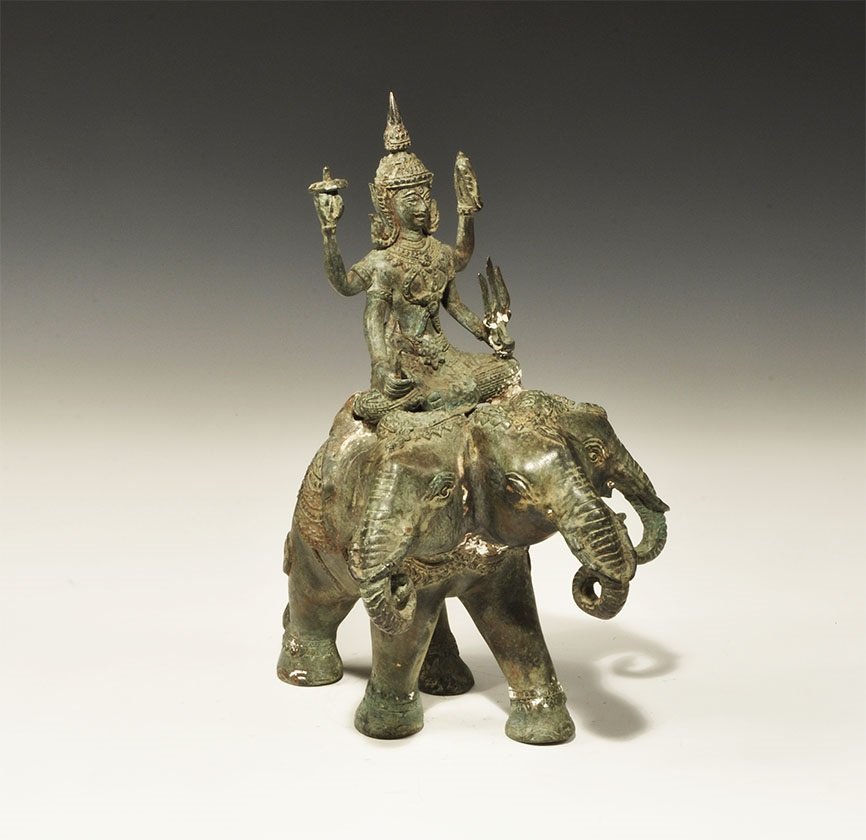 Indian Style Bronze Indra Figurine: An undated archaistic cast figurine of Indra with weapons in his four hands mounted on his three-headed elephant, Airavata. 1.6 kg, 22cm (8 1/2"). From an old London collection, formed in the 1980s.