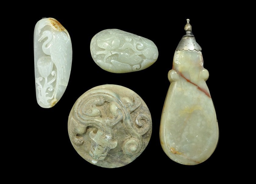 Chinese Carved Jade and Stone Artefact Group: A mixed group of undated archaistic items comprising: a discoid stone lid with reserved dragon motif; an ovoid jade pendant with heron and foliage motifs; an ovoid jade pendant with lady bird and ling