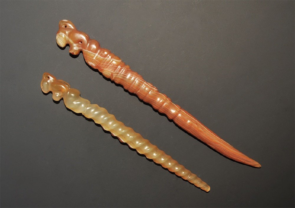 Chinese Stone Dress Pin Pair: 20th century AD. A pair of carved dress pins in carnelian and agate, each with ribbed shank and zoomorphic finial pierced to accept a thread. 161 grams total, 19-23.5cm (7 1/2 - 9 1/4"). Property of a