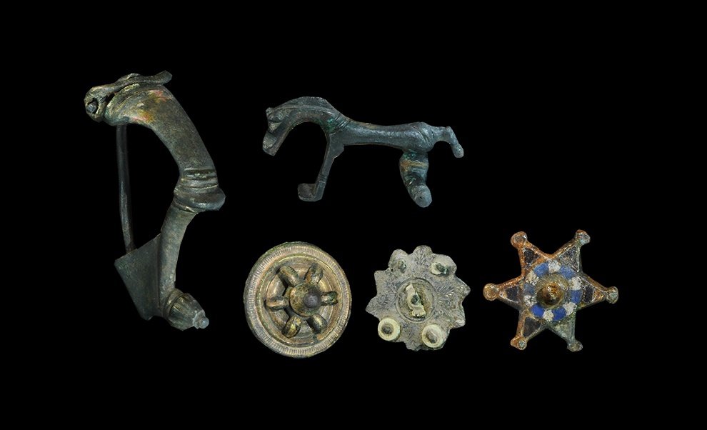 Roman Bronze Brooch Group: 1st-2nd century AD. A mixed group of brooches comprising: a large bow brooch of kräftig profilierte type with transverse ribs to the bow and rosette knop finial; a horse-shaped bow brooch; a disc bro