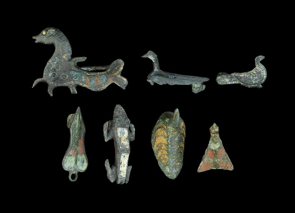 Roman Bronze Plate Brooch Group: Mainly 2nd century AD. A mixed group of cast zoomorphic plate brooches comprising: a frog with raised pellet eyes, two enamelled panels to the upper face; a hollow ovoid bird with enamelled crescents 