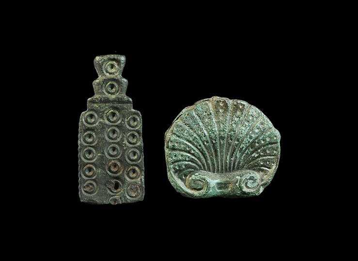 Byzantine Bronze Strap End Group: 7th-11th century AD. A mixed group of cast fittings comprising: a pair of scallop plaques with volute scroll outer edges, pelletted segmentation, mounted back-to-back on a belt or strap; a bifacial re