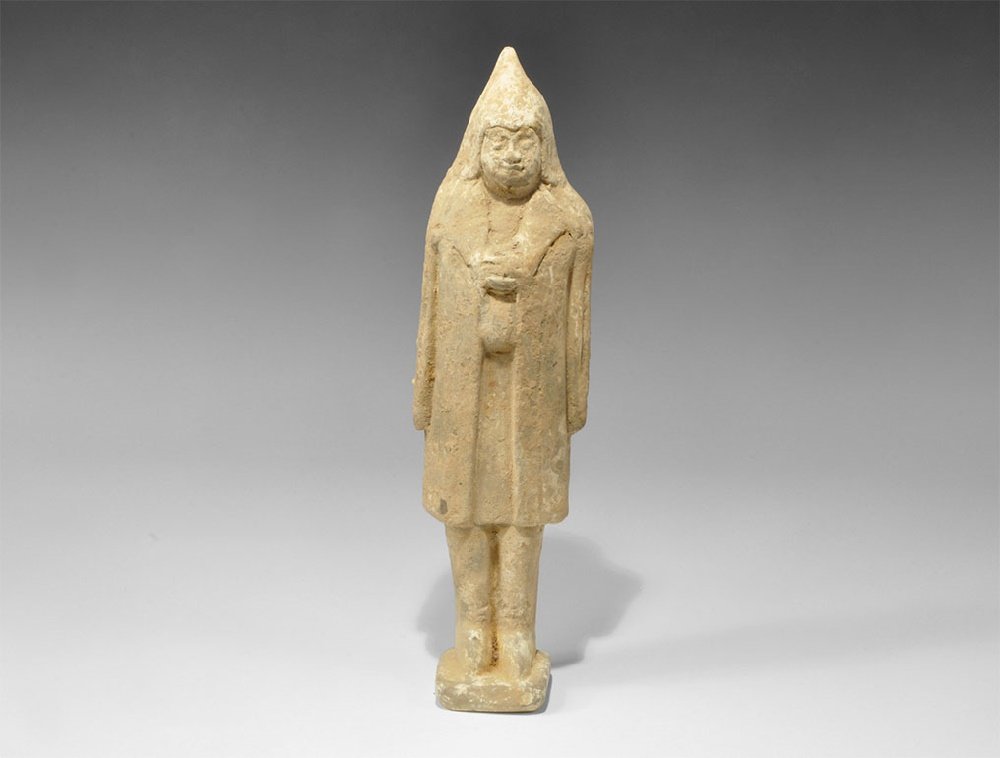 Chinese Ceramic Soldier Figurine: Northern Wei Dynasty, 386-534 AD. A cast D-section figurine of a soldier in hooded long-sleeved coat, hands clasped at the chest. 716 grams, 27cm (10 3/4"). From an important London collection, acquir