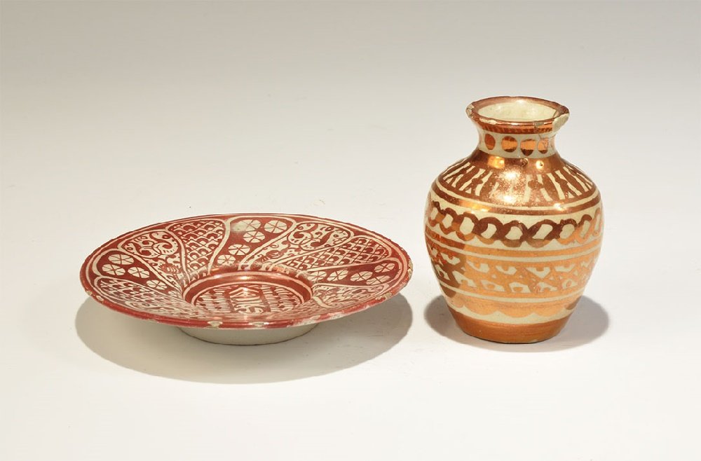 Islamic Hispano Moresque Ware Vase and Dish?: 19th century AD or earlier. A group of two white-glazed ceramic vessels comprising: a squat pot with horizontal bands of geometric ornament; a saucer with 'GM' in a cartouche at the centre, radiating 