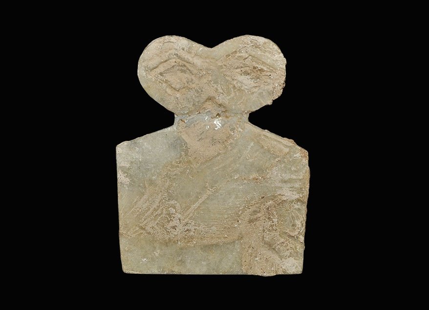 Near Eastern Alabaster Tel Brak Eye Idol: Circa 3000 BC. An alabaster eye idol, flat in section, with trapezoidal body and two large discoid eyes above. 17 grams, 71mm (2 3/4"). Property of an East London gentleman; believed found at Tel Brak