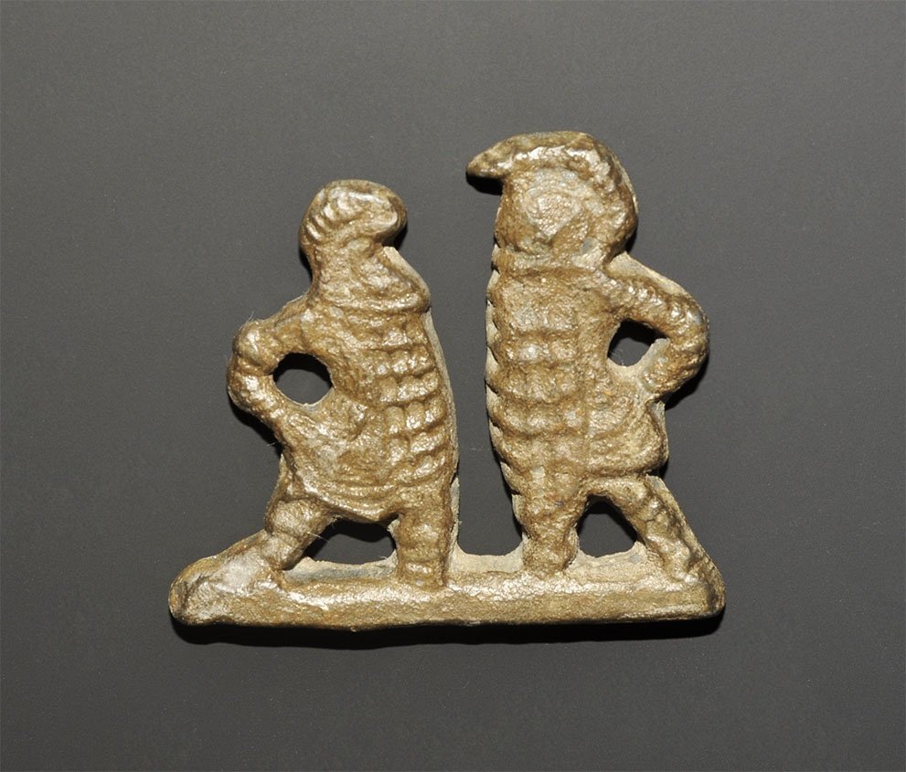 Roman Lead Gladiator Combat Model: 2nd-3rd century AD. A substantial cast model of two murmilo gladiators advancing against each other on a base, each with crested helmet and large rectangular shield, padded manica armour for the arm. 
