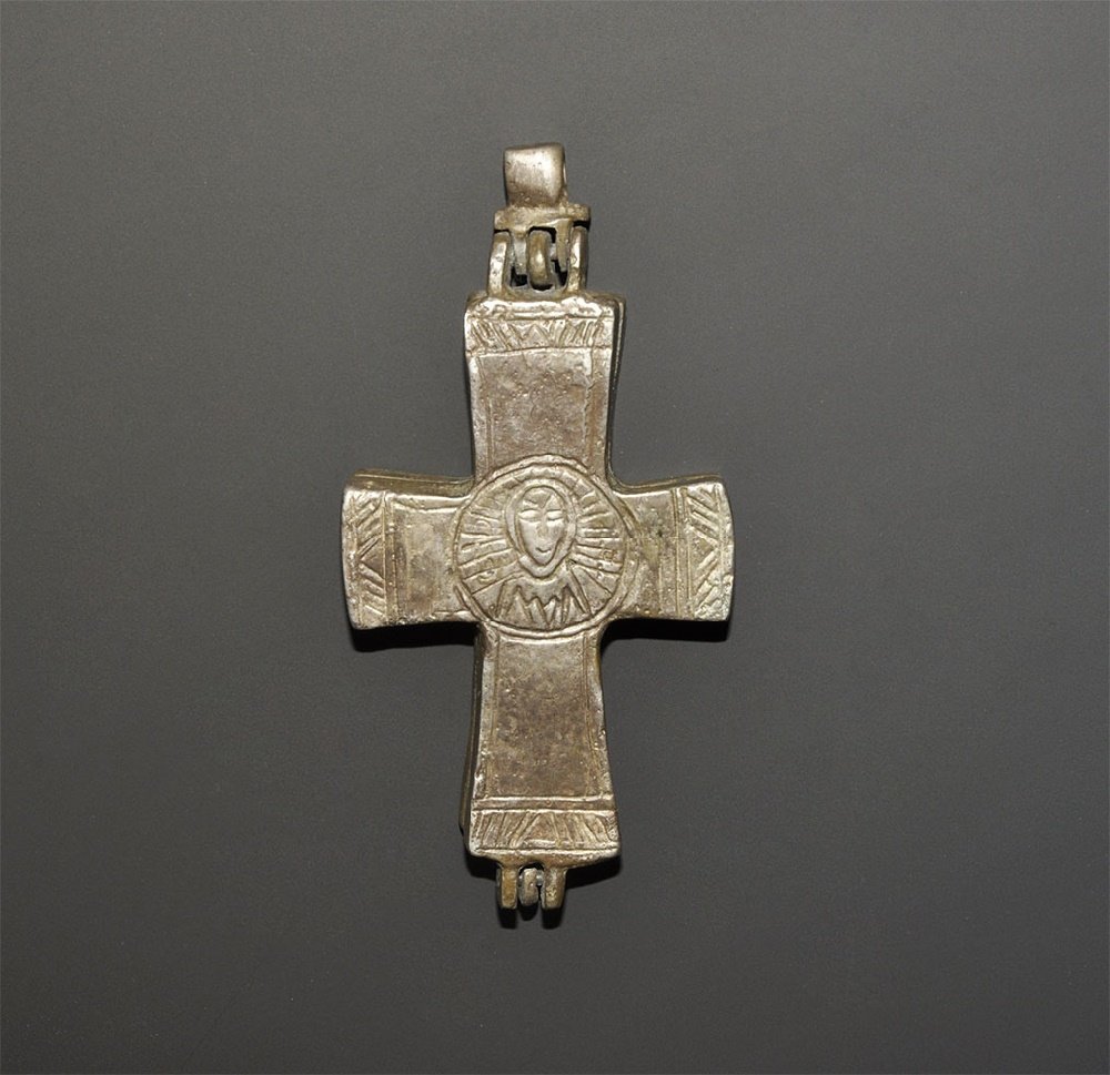 Byzantine Style Reliquary Cross Pendant: 8th-12th century AD. A cast bifacial reliquary cross pendant with suspension loop and hinge; to the obverse the image of Mary with infant Jesus and two flanking busts, 'MP?' above; to the reverse, bus