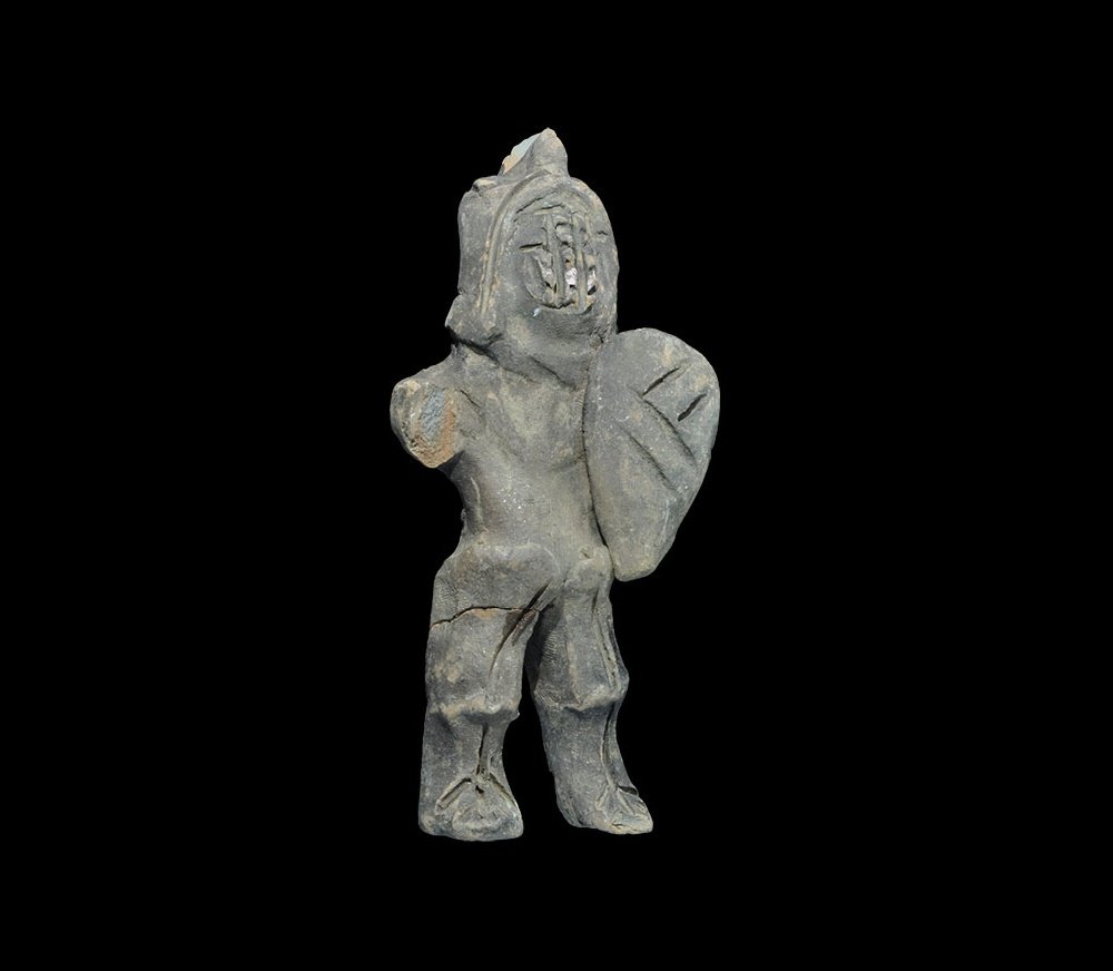 Roman Ceramic Gladiator Figure: 1st century BC-3rd century AD. A terracotta model gladiator of murmillo type with large crested helmet, armour to the legs, small shield to the left arms. 100 grams, 12.5cm (5"). From an old European 