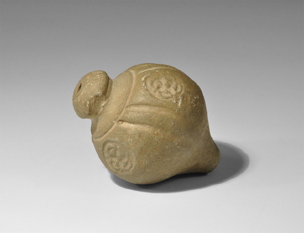 Byzantine Ceramic 'Greek Fire' Hand Grenade: 9th-11th century AD. A hollow ceramic vessel with bulbous body and conical base intended to be filled with explosive liquid and a wick, and used as a hand grenade; band of impressed rosettes to the sh