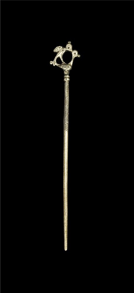 Islamic Silver Hair or Dress Pin: A dress pin with tapering shaft and openwork head; the shaft with rilled herringbone pattern to the upper third; the head formed as a sitting bird surmounted by a second bird with spread wings, both w