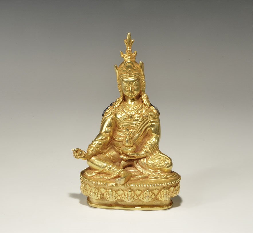 Chinese Style Tibetan Gilt-Bronze Sage Statuette: An undated archaistic hollow-cast figurine of the Buddhist sage Padmasanbhava seated on a lotus-blossom base, holding symbols in the hands. 508 grams, 15.5cm (6"). Acquired on the London art market be