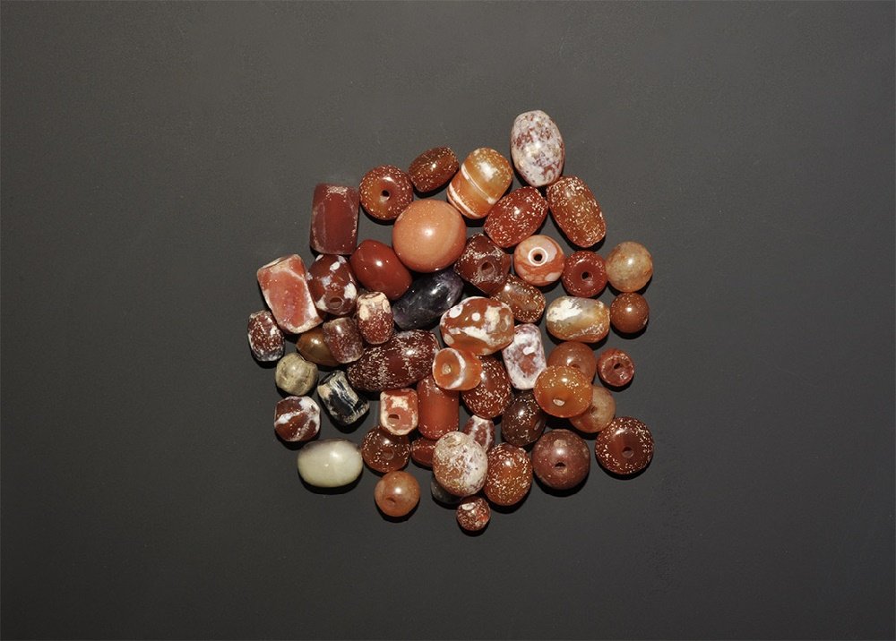 Western Asiatic Carnelian, Agate and Other Bead Group: 20th century AD. A quantity of carnelian, agate and other beads in various shapes; some with etched decoration. 128 grams, 12-19mm (1/2 - 3/4"). Acquired on the London art market before 2000. TimeLine