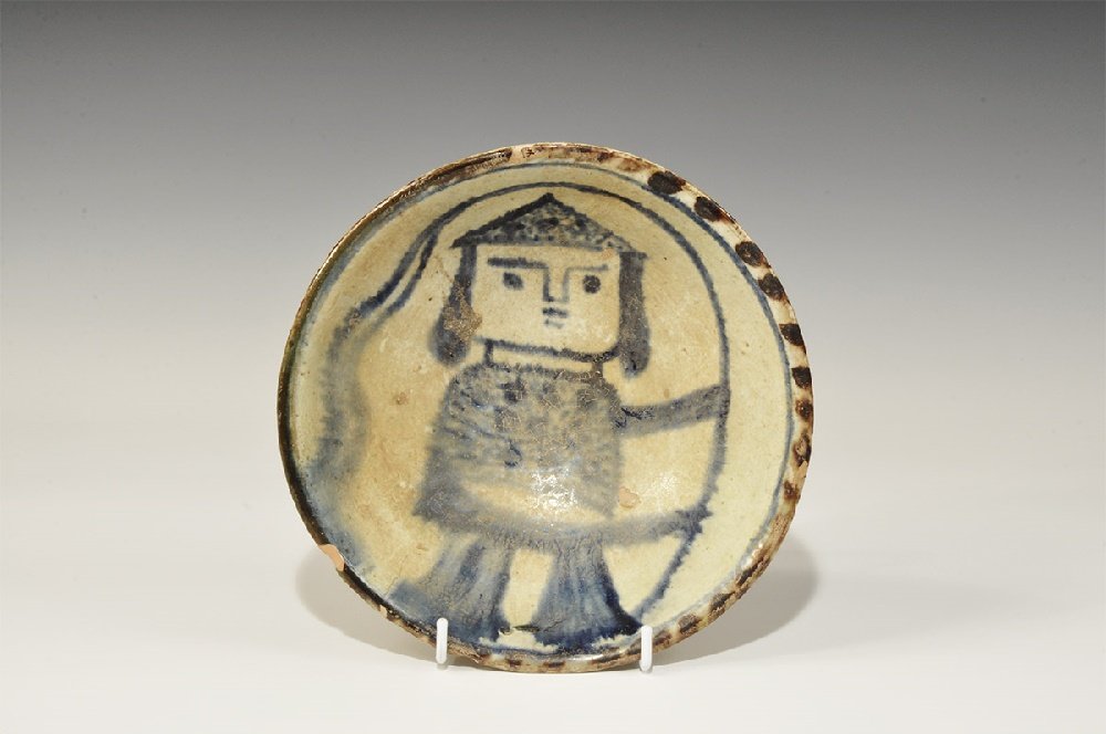 Islamic Style Glazed Ceramic Bowl: A bell-shaped buff-glazed undated archaistic bowl with basal ring, band of brown pellets to the rim, central motif of a blue helmetted soldier with a flag. 398 grams, 20cm (8"). From a central London 