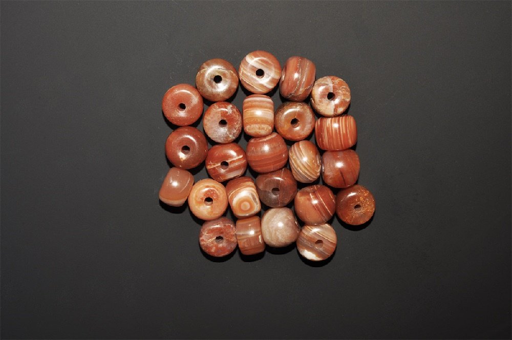 Burmese Banded Agate Bead Collection: A group of twenty undated pink banded carnelian barrel-shaped beads. 171 grams total, 18mm (3/4"). Private collection, West London, UK; acquired in the 1990s. TimeLine Auctions Ltd arranges printed ca