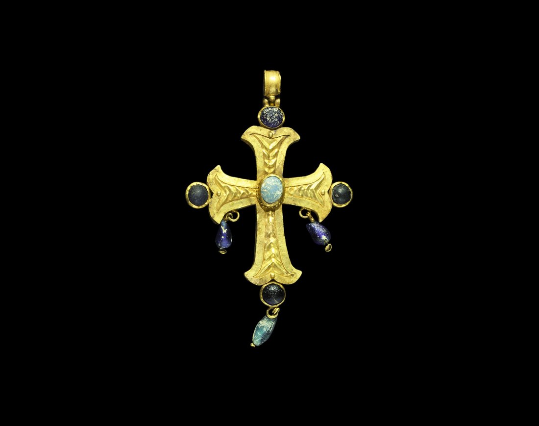 Byzantine Gold Pectoral Cross Pendant with Glass Inlays: 6th-7th century AD. A hollow fabricated cruciform pendant comprising: a sheet gold cross moline with repoussé chevrons to the middle of each arm; a cell to the end of each arm with dark blue glass ca