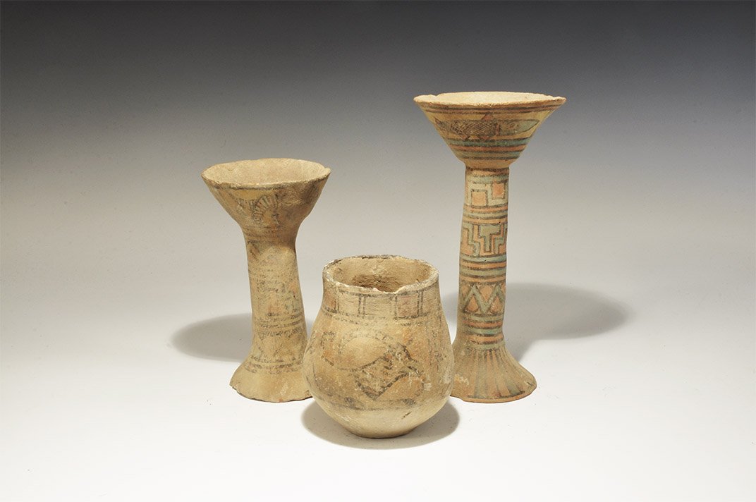 Indus Valley Mehrgarh Polychrome Ceramic Vase and: 3300-1700 BC. A mixed group comprising: two tall narrow-stemmed chalices, each with flared bowl and base, polychrome geometric ornament; a bulbous jar with polychrome geometric panels, advancing goat 
