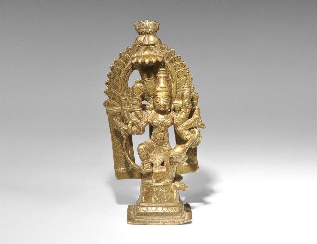 Indian Bronze Goddess Durga Mahishasuramardini Figurine: India, 19th-early 20th century AD. Cast bronze figure of the goddess Durga slaying the buffalo demon; the goddess stands on a decorative base and has six arms holding various weapons and stands on the