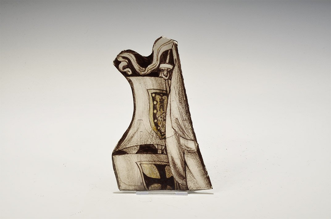 Post Medieval Stained Glass Heraldic Window Fragment: 19th century AD. A panel of window glass with painted design of a ship's mast with curled pennon, topsail with heraldic heater-shield design, section of lower sail with cross patté, furled sail or ba