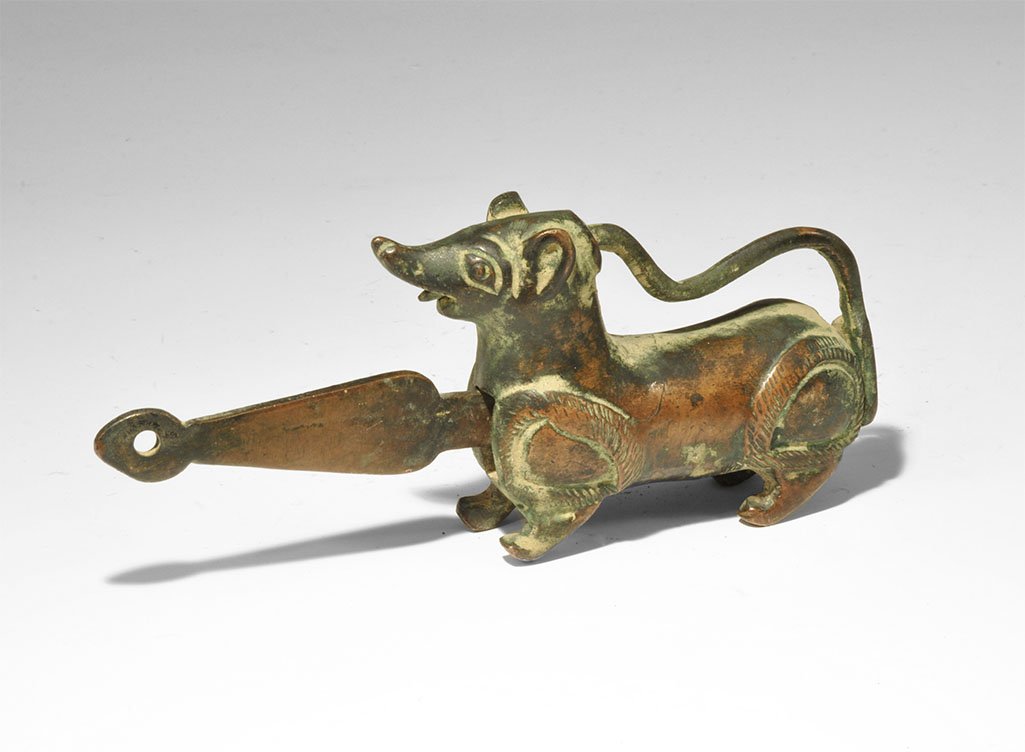 Indian Bronze Mongoose Padlock: 20th century AD. A hollow-cast model mongoose with the tail forming the loop of the lock, leaf-shaped bow to the key inserted into the chest, tip of the tail released through the open mouth. 385 grams