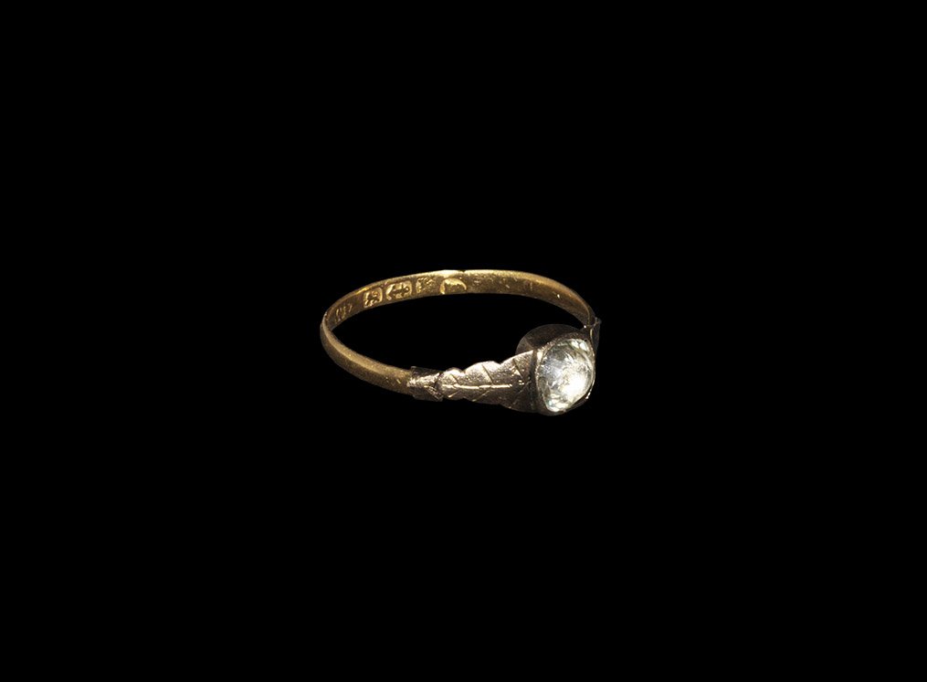 Post Medieval Gold Ring with Stone: Hallmarked 1833.. A delicate flat-section hoop with oak-leaf motif to the shoulders, square cell and inset facetted crystal; maker's mark to the inner face 'WF' for William Fowke, hallmarked with a li