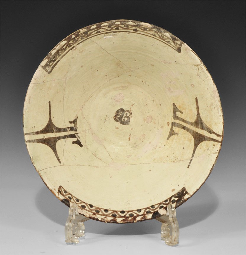 Islamic Nishapur Glazed Bowl: 10th century AD. A cream-glazed ceramic funicular bowl with geometric partial borders and motifs in dark brown to the inner face. 865 grams, 26.5 cm (10 1/2"). Property of a gentleman; acquired 1985-1