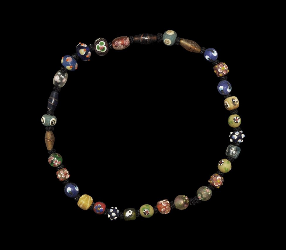 Islamic Safavid Style Mosaic Bead Necklace: A restrung choker-length necklace of undated archaistic glass beads of globular, biconical and cuboid design, some with applied knops. 71 grams, 44cm (17 1/4"). Acquired on the London art market befor