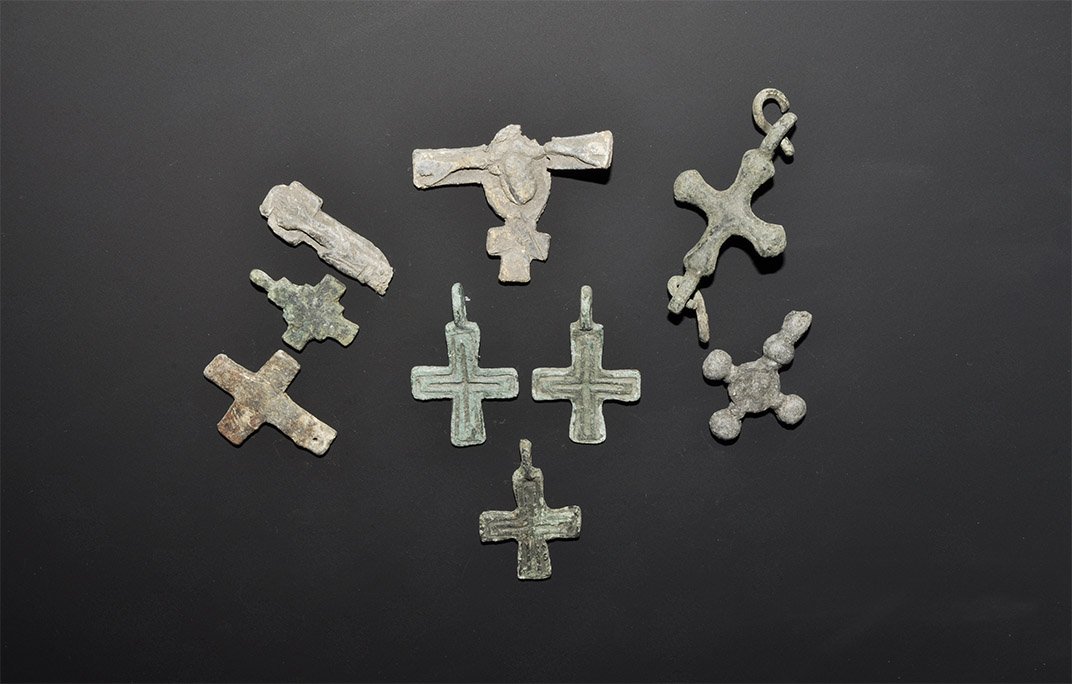Byzantine Cross Pendant Group: 10th-13th century AD. A mixed group of bronze and lead cruciform pendants comprising: three bifacial with voided cross motif; one with stepped arms; one equal-armed, plain, pierced to one arm; one dis