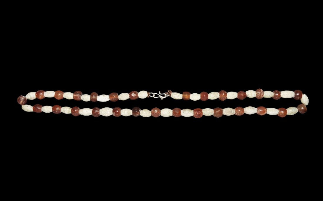 Roman Carnelian and Bead Necklace: 1st-3rd century AD. A restrung necklace of barrel-shaped ceramic beads and biconical carnelian beads; modern clasp. 58 grams, 60cm (23 1/2"). From the collection of a North West London gentleman; acqu