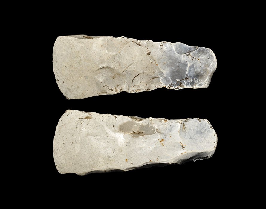 Stone Age Scandinavian Polished Flint Axehead: Neolithic, 6th-2nd millennium BC. An unusual axehead with polished cutting edge; the form slightly asymmetric with one side concave and an offset convex cutting edge with squared sides; formed in a wh