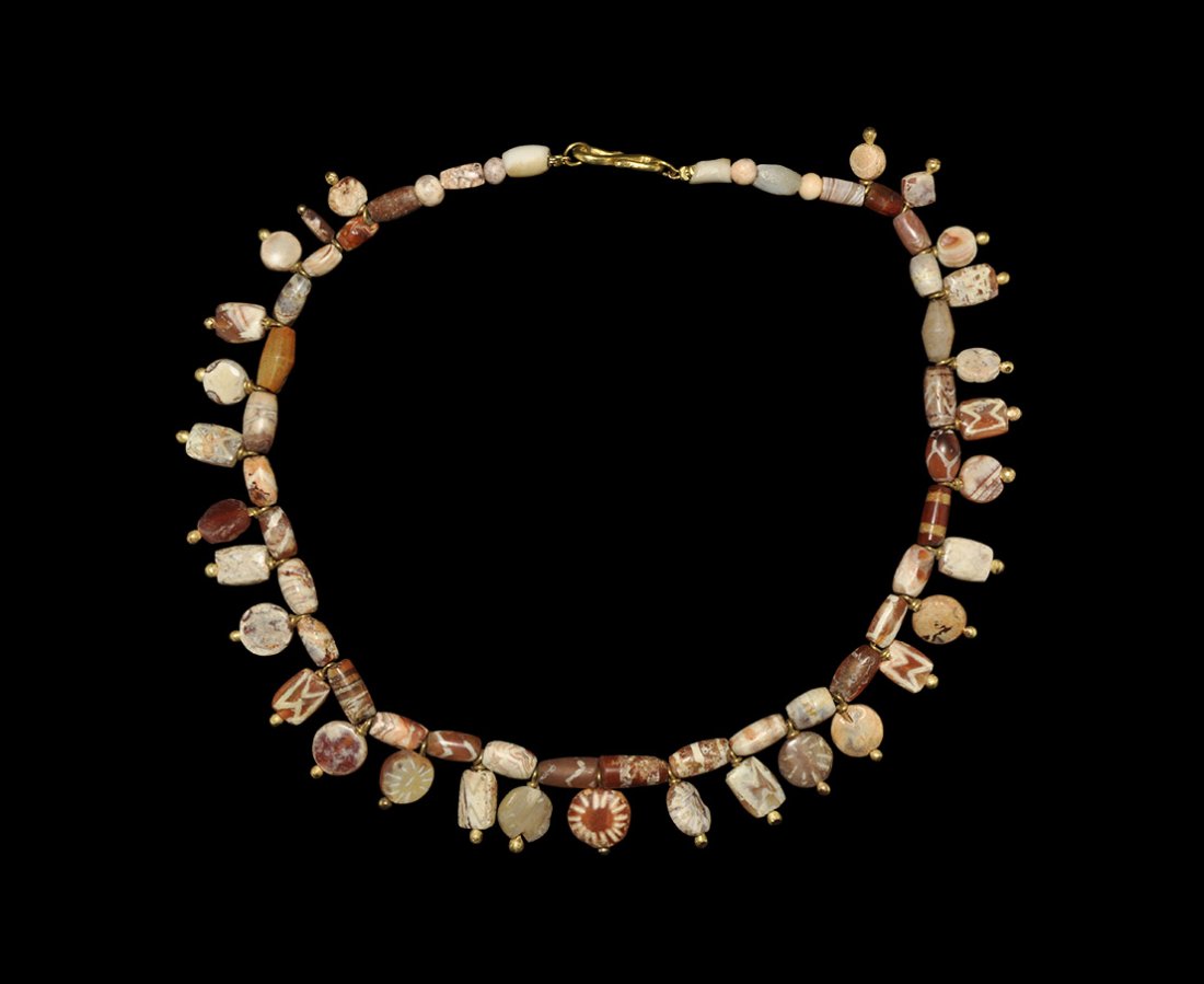 Indus Valley Etched Carnelian Pendant Necklace: 13th-14th century BC. A restrung necklace of tubular glass and carnelian beads and discoid pendants, with sympathetic modern gold elements. 33 grams, 36cm (14"). Ex Yagello collection; acquired in a L