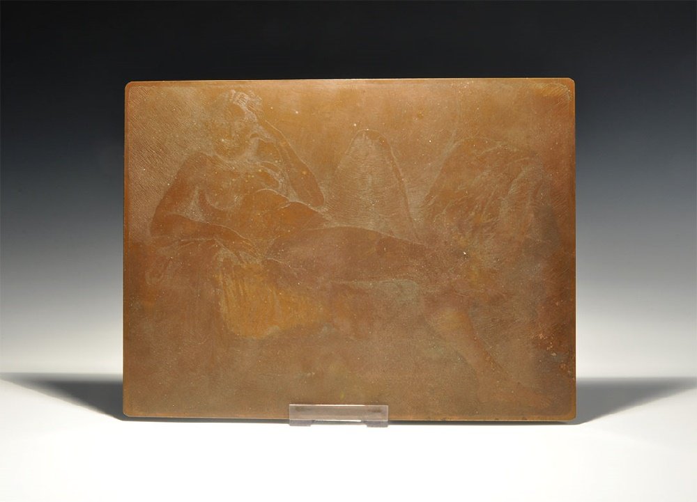 Post Medieval Reclining Nude Print Plate: Circa 1920. A rectangular copper-alloy printer's plate depicting a female nude reclining on a sofa, weight supported on the right arm and left hand raised to the temple. 529 grams, 25.5x19cm (10 x 7 1
