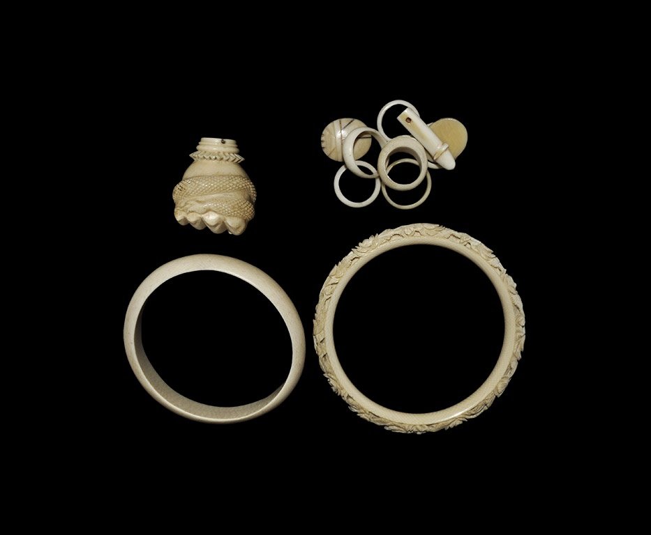 Chinese Bangle, Bead, Pendant, Hand & Ring Group: 19th-early 20th century AD. A mixed group of carved ivory items comprising: five plain D-section finger rings; a D-section finger ring with hatched panel to the bezel; two plano-convex scarab beads; a