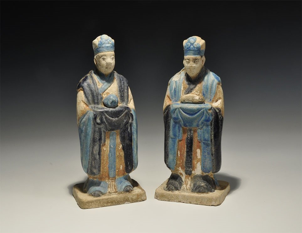 Chinese Blue-Glazed Zodiac Figurine Pair: An undated archaistic pair of glazed ceramic figurines in Ming Dynasty, 1368-1644 AD style comprising: one standing on a rectangular base in light blue robe with dark blue detailing holding a rat; the