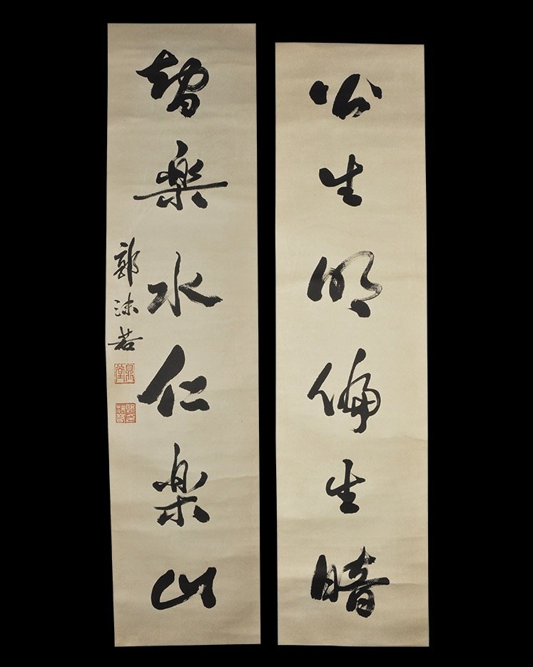 Chinese 'Guo Moruo' Calligraphic Scroll Pair: 20th century AD. A pair of scrolls, each a rectangular paper panel on a fabric backing with wooden roller; column of large calligraphic text, one with smaller text and two red chop seals; attributed t