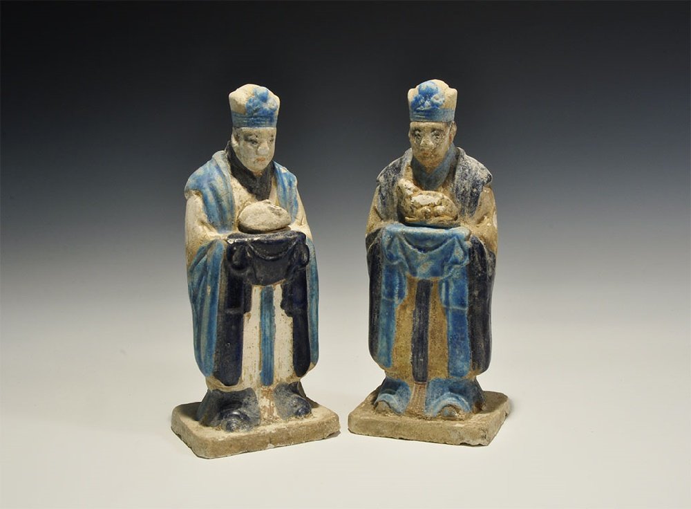 Chinese Blue-Glazed Zodiac Figurine Pair: An undated archaistic pair of glazed ceramic figurines in Ming Dynasty, 1368-1644 AD style comprising: one standing on a rectangular base in light blue robe with dark blue detailing holding a rat; the