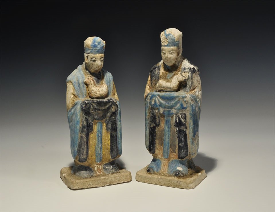 Chinese Blue-Glazed Zodiac Figurine Pair: An undated archaistic pair of glazed ceramic figurines in Ming Dynasty, 1368-1644 AD style comprising: one standing on a rectangular base in light blue robe with dark blue detailing holding a hen; the