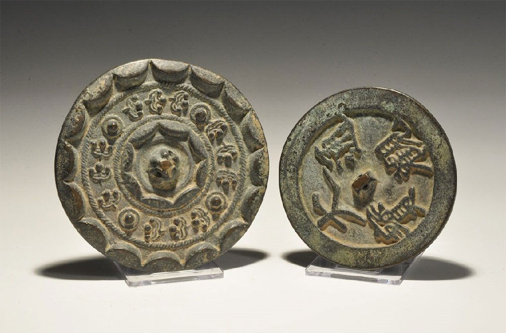 Chinese Style Mirror Pair: A mixed pair of undated archaistic discoid bronze mirrors, one with concentric scrolled bands, the other with calligraphic text. 318 grams total, 78-92mm (3 - 3 3/4"). Acquired on the London art marke