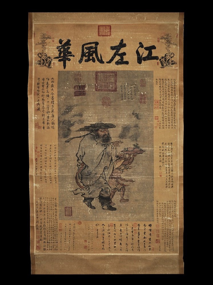 Chinese Style Scroll Picture: 20th century AD. A rectangular paper panel on a fabric backing with wooden roller; painting of a robed figure of Bodhidharma with a ruyi sceptre and his attendant with a platter of food; blocks of cal