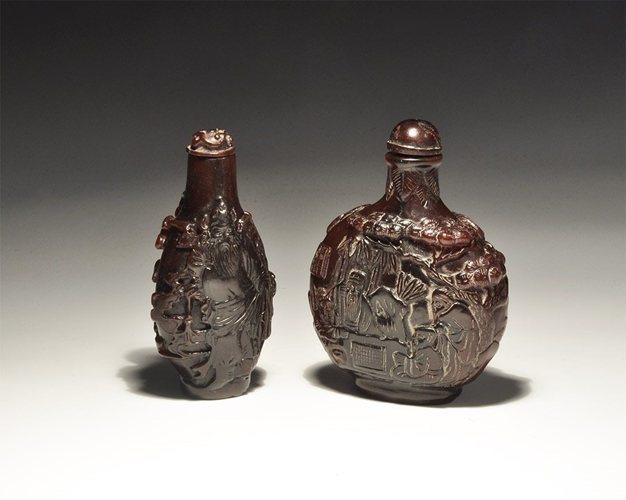 Chinese Style Perfume Bottle Group: 20th century AD. A mixed group of composition perfume bottles comprising: one with high-relief figure of a seated sage and a tree; one with scenes of men in discussion. 144 grams total, 83-86mm (3 1/4