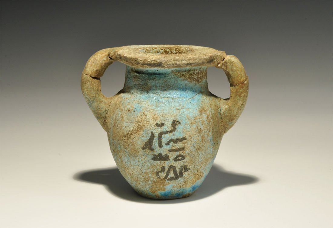 Egyptian Style Hieroglyphic Vessel: 20th century AD. A blue glazed composition jar with flange rim and two round-section handles, black hieroglyphs to both faces. 371 grams, 10cm (4"). Acquired on the London art market before 1995. [No 