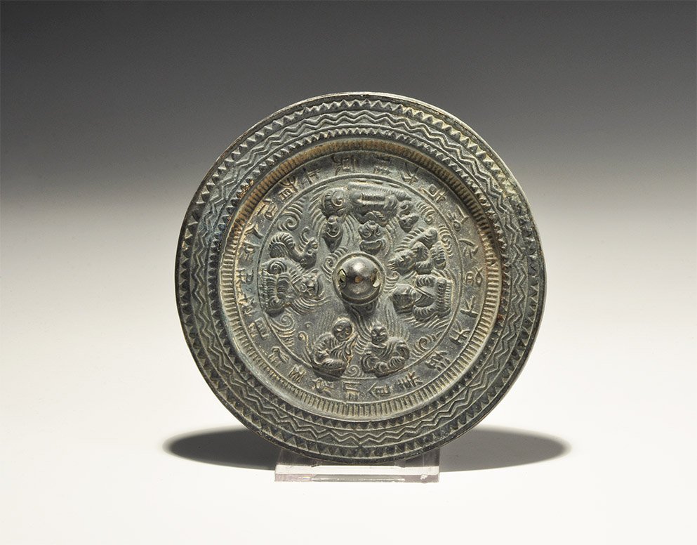 Chinese Mirror with Buddhist Icons: . An undated archaistic bronze discoid mirror with icons of the seat Buddha with surrounding text. 357 grams, 12.5cm diameter (5"). Private collection, West London, UK; acquired in the 1990s. [No Rese