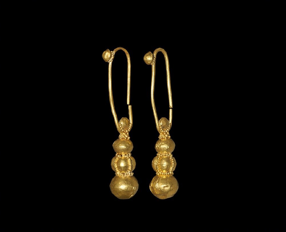 Byzantine Gold Earring or Adornment Pair: 10th-11th century AD. A matched pair of gold earrings, each a round-section wire loop with hollow sphere and granule collar, hollow disc to the lower end of the loop with granules, three graduated hol