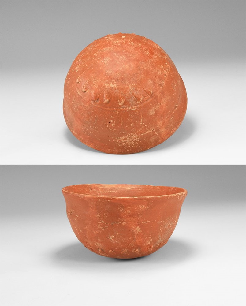 Roman Cup with Floral Decoration: 1st -3rd century AD. A ceramic cup in terra sigillata with rounded bottom and flared rim, overlapping petal motifs to the underside. 192 grams, 12cm (4 3/4"). From a German collection; acquired on the