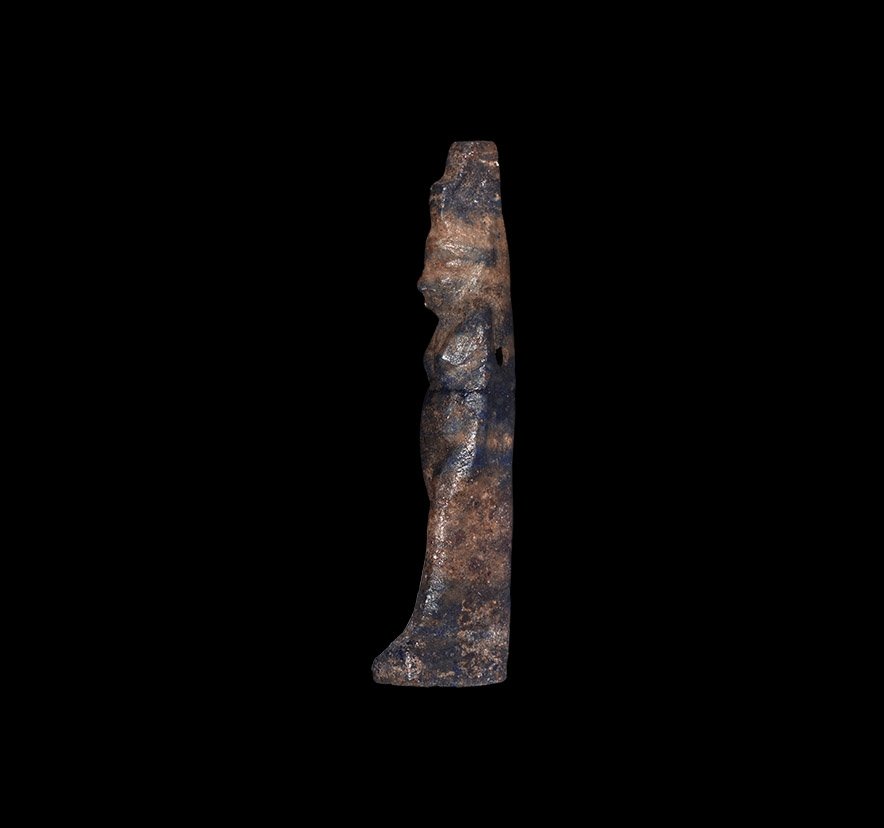 Egyptian Isis Amulet: Late Period, 664-332 BC. A lapis lazuli amulet of a standing goddess Isis wearing a throne crown; supporting pillar to the back, pierced for suspension. 1.45 grams, 30mm (1 1/4"). From an early 20th c