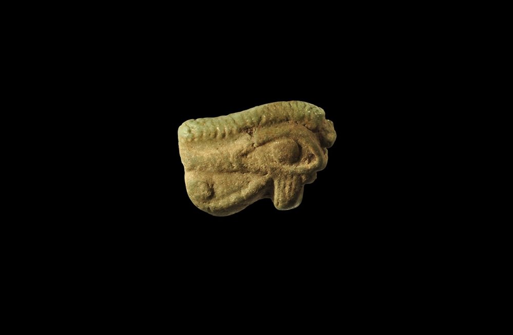 Egyptian Wedjat Eye Amulet: Late Period, 664-332 BC. A large green glazed composition wedjat with hatched brow. See Andrews, C. Amulets of Ancient Egypt, London, 1994, p.43-4, for discussion. 4.94 grams, 29mm (1 1/4"). Property 