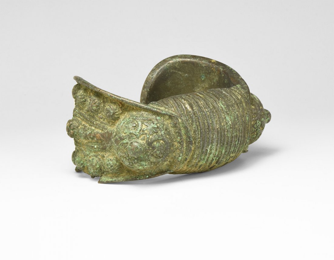 Post Medieval 'Rogatka' Bracelet: 18th-19th century AD. A hollow-formed bronze bracelet with flanges to the outer edges containing vertical rosettes and pellets, domed bosses, textured band to the centre. See similar examples in Regio