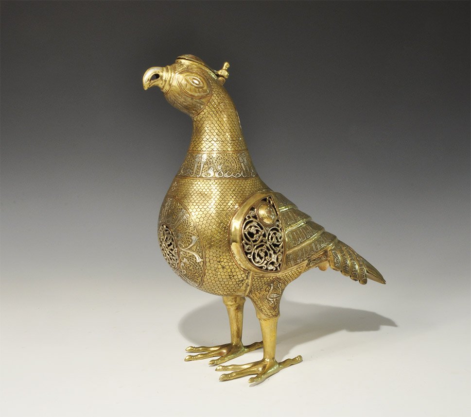 Islamic Style Silver-Inlaid Bird Incense Burner: An undated archaistic incense burner in the shape of a standing bird with extended claws; openwork arabesque ornament designs to the chest, wings, neck and tail; bands of silver-inlaid calligraphic te